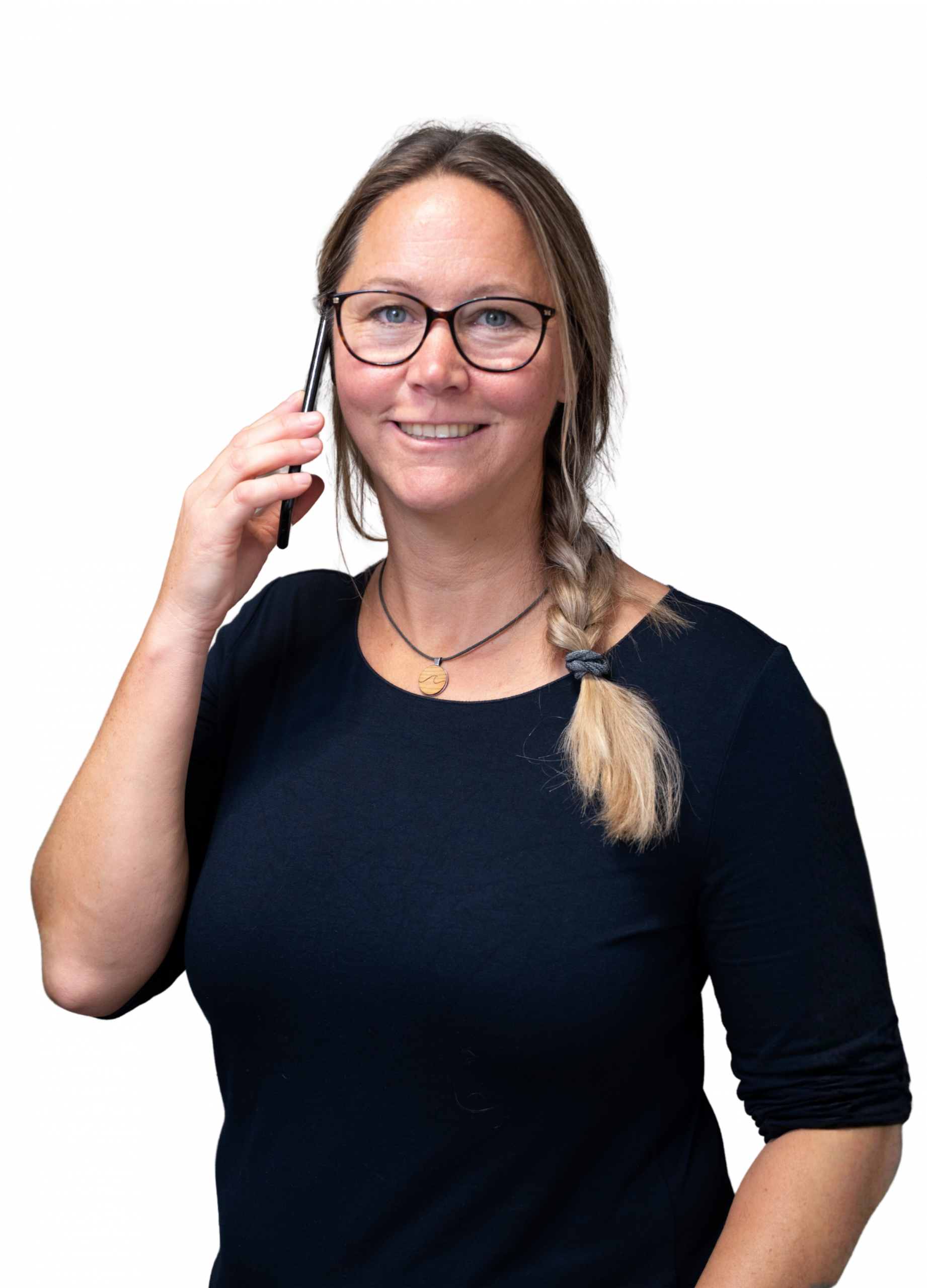 Eine freundlich schauende Frau telefoniert mit ihrem Smartphone und schaut dabei in die Kamera.